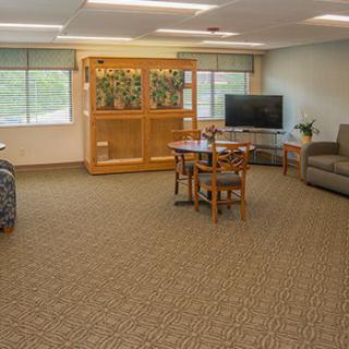 Spacious living room with comfortable seating, a television, and large windows.