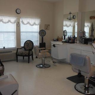 A cozy hair salon interior with styling chairs, mirrors, and equipment.
