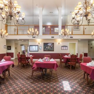 Elegant dining room with chandeliers and neatly arranged tables.