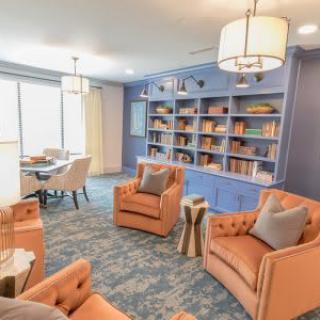 A cozy living room with colorful furniture and a well-organized bookshelf.