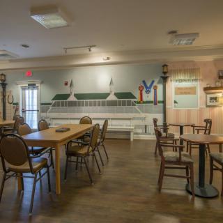 A cozy dining area with wooden tables and chairs, complemented by wall decorations.