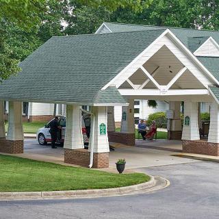 A covered driveway entrance with a car parked under the canopy.
