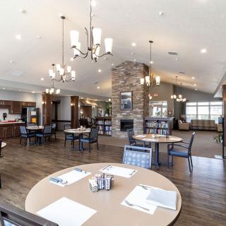 A spacious and modern dining area with elegant chandeliers and comfortable seating.