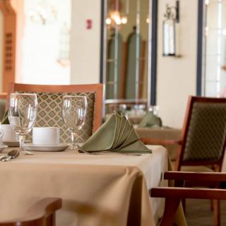 An elegantly set table in a restaurant, featuring neatly arranged glasses and folded napkins.