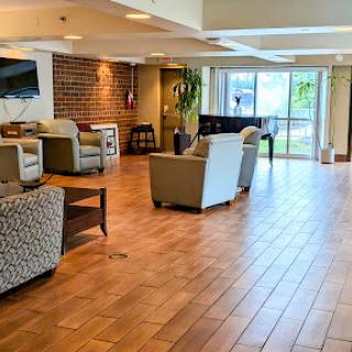 A spacious and modern lobby featuring comfortable seating and a warm wooden floor, perfect for relaxation.