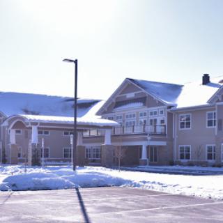 A serene winter scene featuring a modern residential building blanketed in snow.
