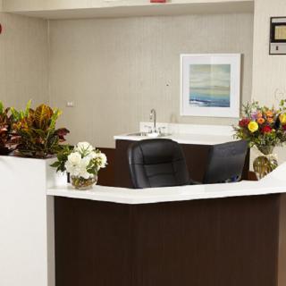 A welcoming reception desk decorated with floral arrangements in an office setting.
