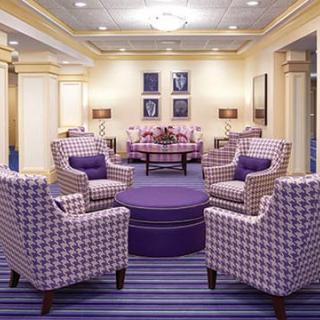 A modern lounge with purple-themed furniture and a cozy seating arrangement.