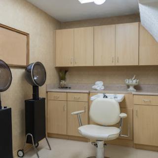 A well-equipped hair salon with modern furnishings and a comfortable styling chair.