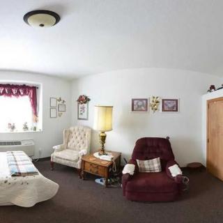 A cozy living room with comfortable armchairs and a well-lit window.