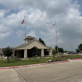A welcoming entrance featuring multiple flags under a cloudy sky.