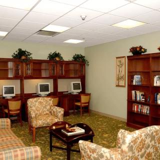 A cozy office space with computers, comfortable seating, and bookshelves.