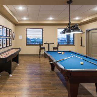 A stylish game room featuring a pool table and shuffleboard, perfect for entertaining guests.