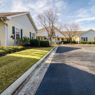 A suburban neighborhood with neatly lined houses and a clear, sunny sky.