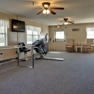 A fitness room with treadmills, a television, and a seating area.