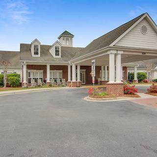 A spacious building with a covered entrance and well-maintained landscaping.