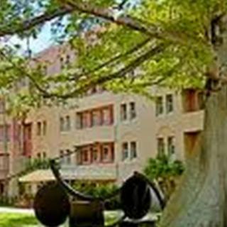 A scenic view of a building with surrounding trees and an outdoor sculpture.