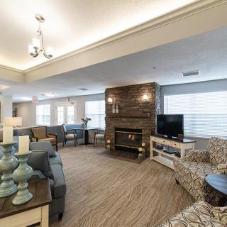 A cozy and spacious living room with a fireplace, comfortable seating, and large windows.