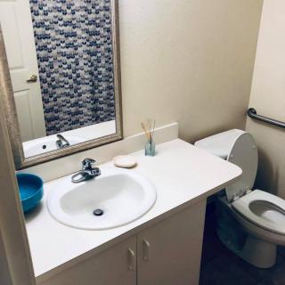 A tidy bathroom with a sink, mirror, and toilet.