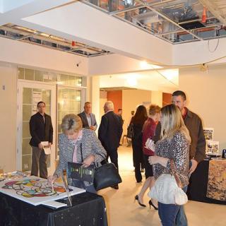 A group of people attending an indoor event with refreshments and conversations.