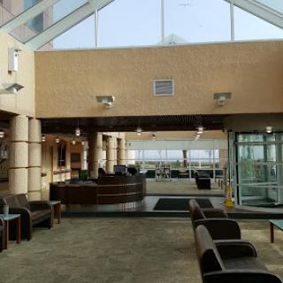 A spacious modern lounge area with comfortable seating and a glass roof, providing a bright and airy atmosphere.