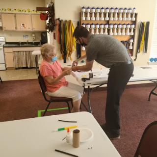 A healthcare worker administering a vaccine to an elderly woman in a community center.