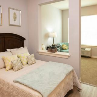 A cozy bedroom with a bed, pillows, and elegant decor.