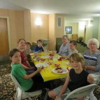 A family gathering around a dining table for a meal.
