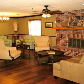 A cozy living room with sofas and a brick fireplace.