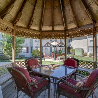 A cozy gazebo with patio furniture offering a garden view.