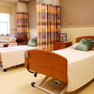 A hospital room with two beds separated by curtains.