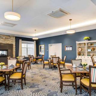 A comfortable and elegantly decorated dining room with multiple tables and chairs, warm lighting, and stylish decor.
