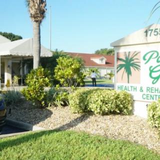 Entrance to a health and rehabilitation center with neatly maintained landscaping and visible signage.