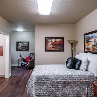 A modern bedroom featuring a comfortable bed, stylish artwork, and cozy decor.
