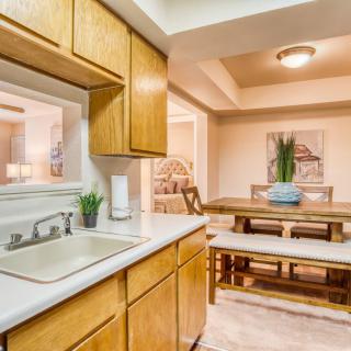 A cozy kitchen with wooden cabinets and a view of the dining area.