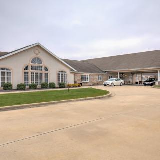 A residential building with a large driveway and well-maintained landscaping.