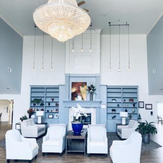 A modern living room with elegant furniture and a large chandelier.
