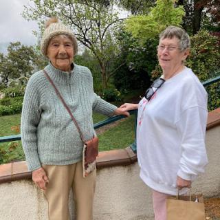 Two elderly women enjoying a day out in a scenic location.