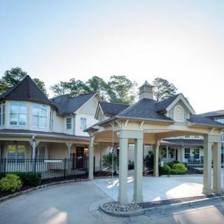 A beautiful residential house with a spacious driveway and surrounding greenery.