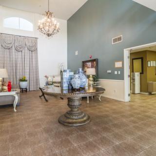 A stylishly furnished living room with a chandelier, elegant decor, and comfortable seating.