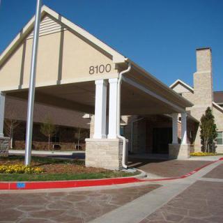 The entrance of a large building with an awning, captured on a clear day.