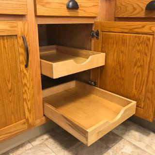 A view of wooden kitchen cabinet drawers showcasing organized storage space.