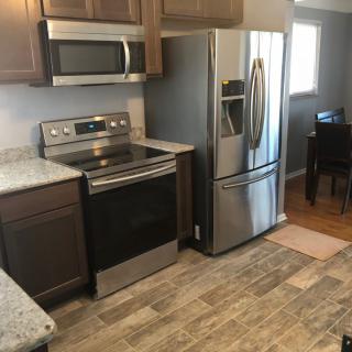 Modern kitchen with stainless steel appliances and hardwood flooring.