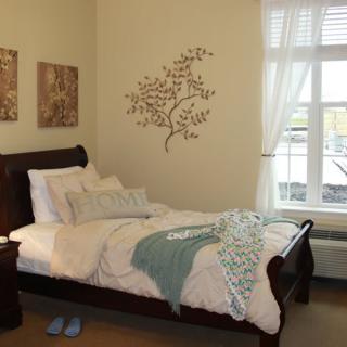 A cozy bedroom with a decorative wall piece and a neatly made bed.