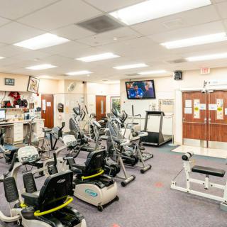 A well-equipped gym with various exercise machines and a treadmill.