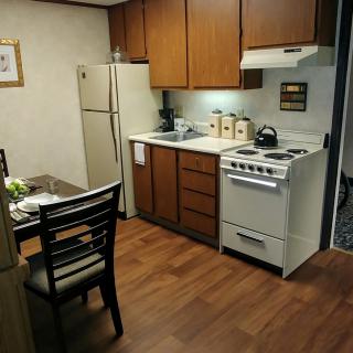 Cozy kitchen with wooden cabinets, a refrigerator, and a stove.