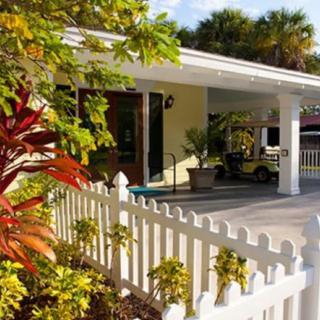 A charming house with a white picket fence and a sunny front yard.
