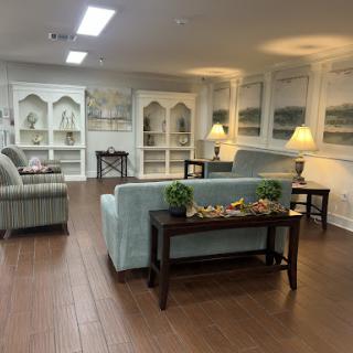 A cozy living room setup featuring comfortable sofas, elegant lamps, and decorative shelving.