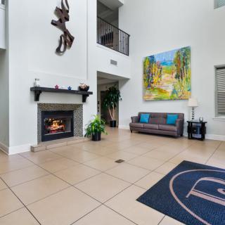 A modern lobby with a fireplace, art on the wall, and comfortable seating.