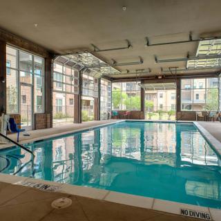 An indoor swimming pool with large windows, providing a bright and airy atmosphere for leisure activities.